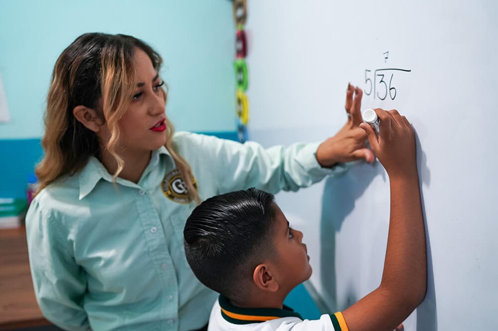 Maestra acompañando a alumno de primaria — Colegio Bambinos