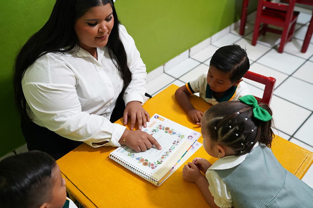 Maestra de preescolar guiando a alumnos de kínder — Colegio Bambinos